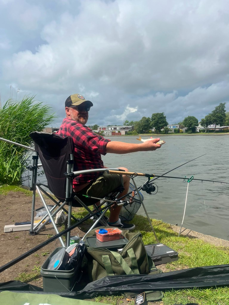 Chris Mitchell holding a fish on a North East bank